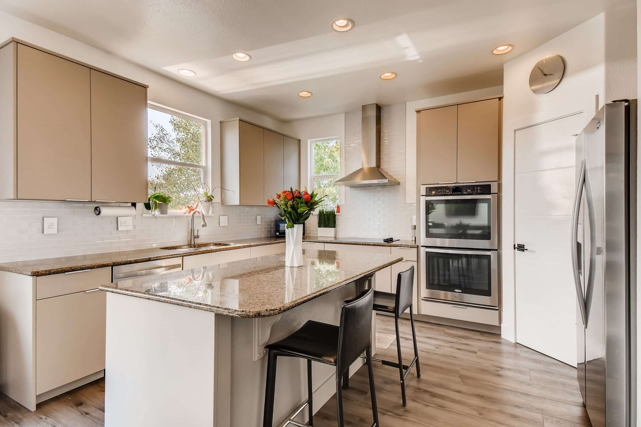 Modern Kitchen Interior Painting and Cabinet Refinishing A bright modern kitchen featuring light beige cabinets, white subway tile backsplash, and neutral wall paint.