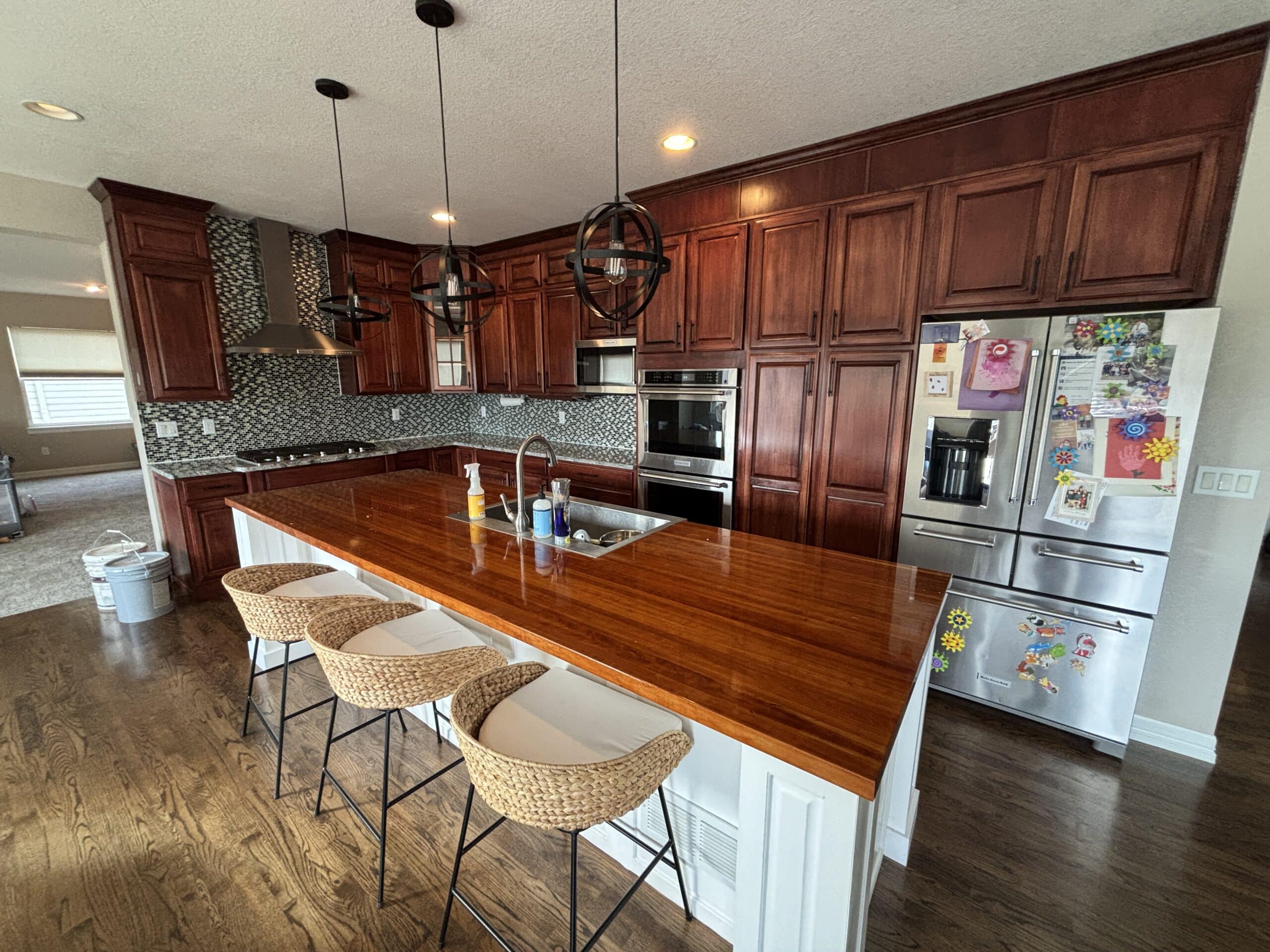 Before - An elegant kitchen with freshly painted gray cabinets and a beautifully stained wooden island countertop.
