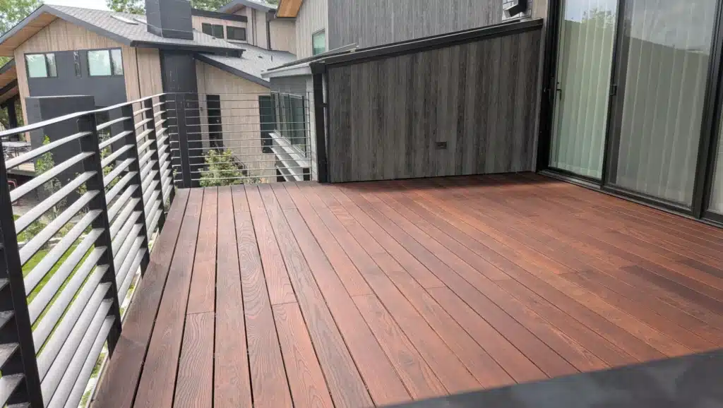 Stained Composite Deck with Metal Railing Finished exterior deck surface at a Colorado home